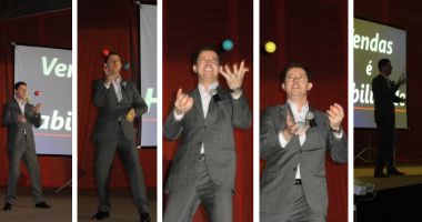 Palestrante de vendas realizando malabarismo no palco para ilustrar equilíbrio, foco e tomada de decisão em ambientes comerciais